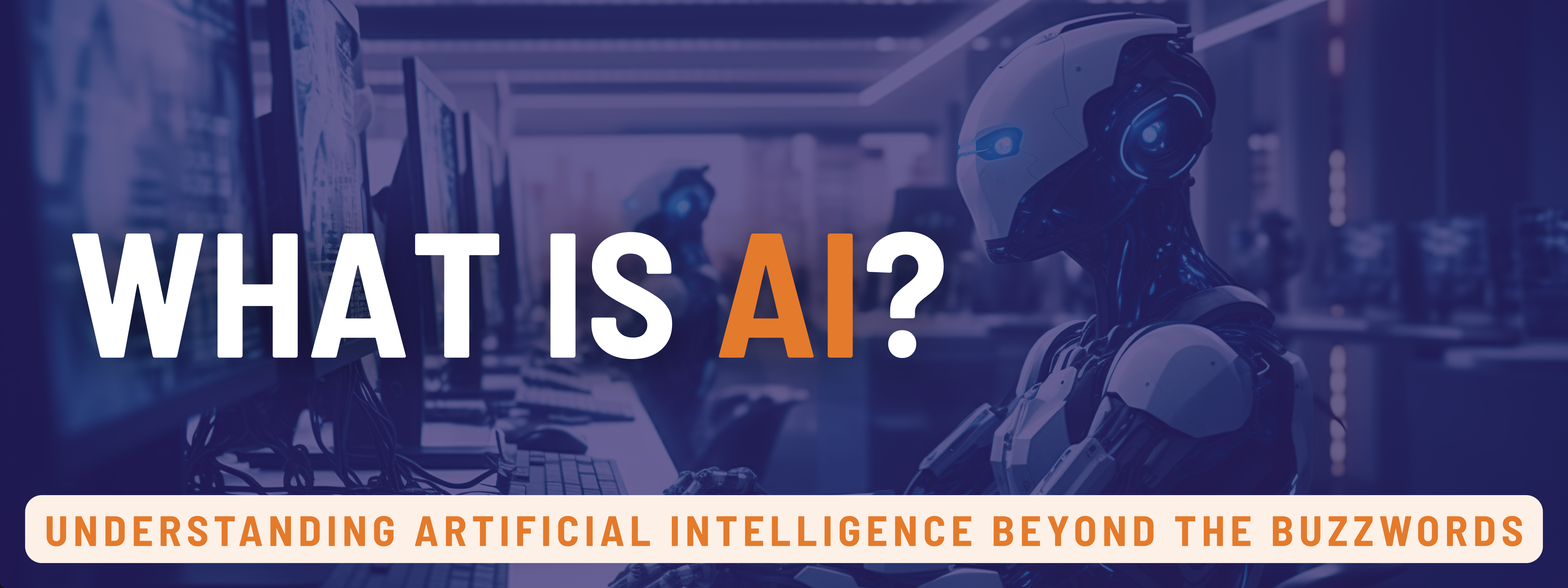 What is AI? The image shows a robot working at a computer setup in an office. The image says "What Is AI? Understanding Artificial Intelligence Beyond the Buzzwords"